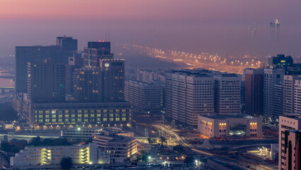 Obraz premium Abu Dhabi city skyline with skyscrapers before sunrise from above night to day timelapse
