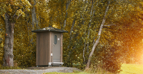 Wooden public restroom in lush greenery