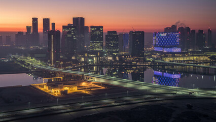 Fototapeta premium Abu Dhabi city skyline with skyscrapers before sunrise from above night to day timelapse