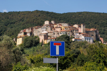 Obraz premium The road sign dead end with the blurred background of Italian traditional village with red roofs 