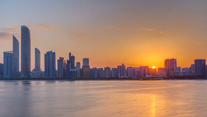 Abu Dhabi city skyline on sunrise time with water reflection timelapse.