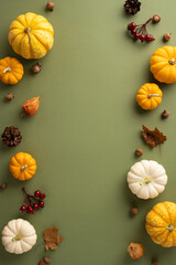 A vibrant vertical autumn-themed background featuring a variety of pumpkins, colorful leaves, acorns, and berries on a green surface. Perfect for seasonal and Thanksgiving designs