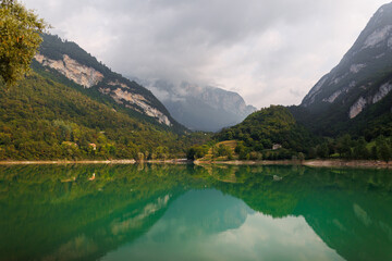 Fototapeta premium Alps Mountain Italian lake Tenno with crystalline pure green water captured with drone