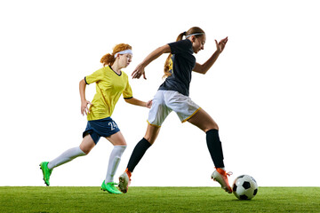 Obraz premium Young athletic woman, sprinting towards ball with her opponent closely following, both fully engaged in soccer match against white background. Concept of sport, competition, tournament, games, event.