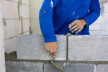 Close up hand construction mason worker bricklayer Engineering people, man construction worker and architecture bricklayers working in work at house construction site. Caucasian men
