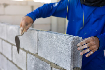 Close up hand construction mason worker bricklayer Engineering people, man construction worker and architecture bricklayers working in work at house construction site. Caucasian men