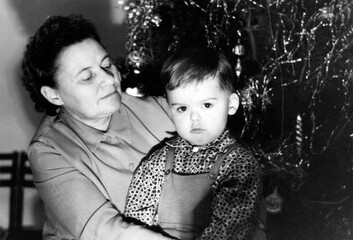 Retro portrait of a grandmother with her grandson near the New Year tree. USSR, Ukraine,...