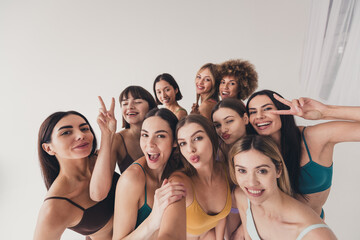 Fototapeta premium No filter studio photo of pretty funny women wear bras hugging tacking selfie showing v-sign isolated beige color wall background