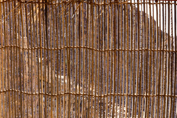 Wall made of cane and palm tree branches, natural mountain shelter in Wadi Shawka, United Arab Emirates.