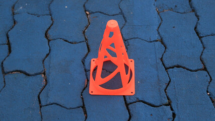 Orange cones and blue cones set up on a blue field for high school sports speed drills.