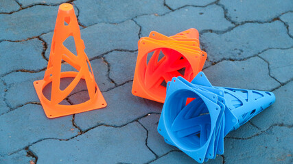 Orange cones and blue cones set up on a blue field for high school sports speed drills.