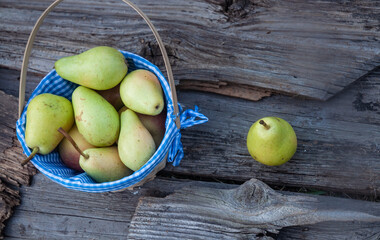 Pears in a knitted basket on a wooden background. No people.