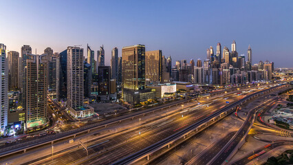 Dubai marina with traffic on sheikh zayed road panorama day to night timelapse lights turn on.