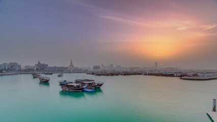 Fototapeta premium Sunset at Doha Bay timelapse with Traditional Wooden Dhow Fishing Boats.