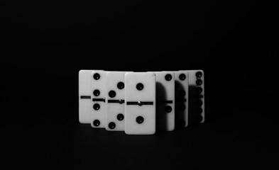 Logical game of dominoes. On a dark background light dominoes