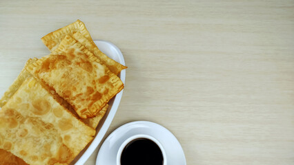 A plate full brazilian typical pastry called pastel and cup of coffee
