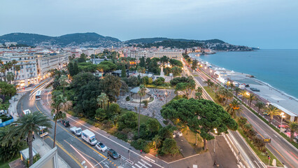 Evening aerial panorama of Nice day to night timelapse, France. Lighted Old Town little streets and waterfront after sunset