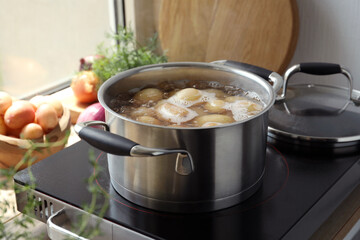 Boiling potatoes in pot on stove in kitchen