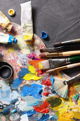Obraz premium Artist's palette, brushes and paints on grey table, flat lay