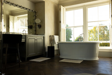 Modern bathroom with freestanding bathtub and large windows, inviting natural light