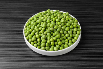 Fresh green peas on black wooden table, closeup