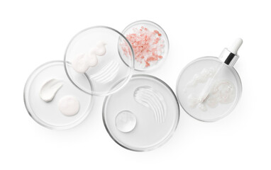 Petri dishes with different cosmetic products and leaves isolated on white, top view