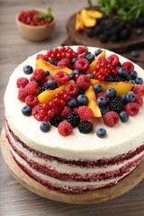 Tasty sponge cake with different fruits on wooden table