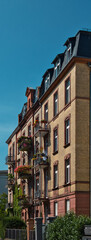 Fototapeta premium old building in Frankfurt am Main with an outside balcony and yellow facade and beautiful decoration on the windows