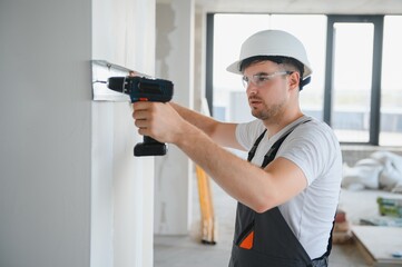 Construction worker installing metal profile for interior partition wall, while building a new house or renovation process