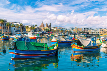 Picturesque fishing village with colorful traditional Luzzu boats in Marsaxlokk, Malta