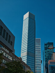 Obraz premium narrow skyscraper in Frankfurt am Main, surrounded by smaller buildings with a clear sky