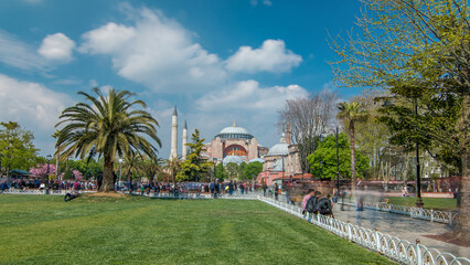 Fototapeta premium Visitors enjoying on a grass timelapse in front of Hagia Sophia Museum in Istanbul, Turkey.
