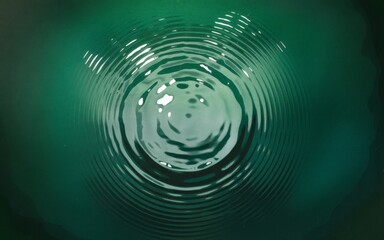 Water ripples. Concentric circles of ripples expanding outwards from a central point on a deep green surface.