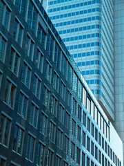 Obraz premium A Detail shots of high-rise buildings with a bluish facade and a beautiful shadow play and round architecture background