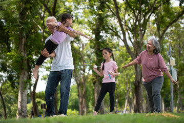 Obraz premium Happy Asian family children having fun and playing with her grandparents in the park