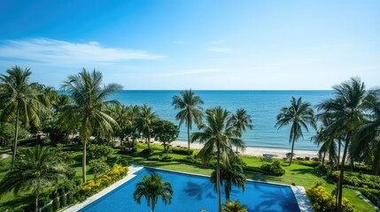 Scenic view from a serviced condominium in Hua Hin, Thailand, overlooking a serene swimming pool, palm trees, and the calm sea under a bright and clear sky