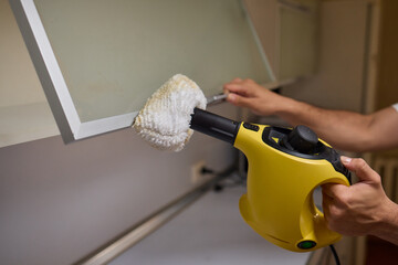 A man uses an innovative cleaning tool in his modern kitchen for cleanliness and organization