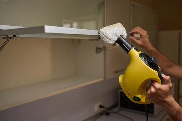 A man uses an innovative cleaning tool in his modern kitchen for cleanliness and organization