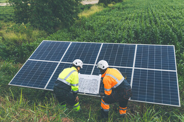 Engineer Checking solar panels in agriculture farm land. Engineer examining solar panels at field. Technicians maintenance solar photo voltaic panels  in agriculture farm field. clean energy