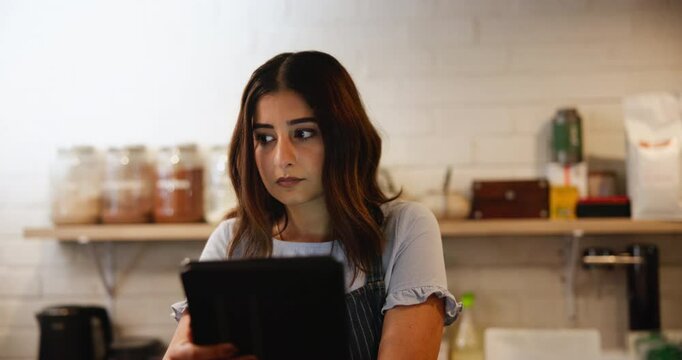 Woman, waitress or tablet in cafe for small business, inventory management and stock check. Girl, barista and server on touchscreen technology for hospitality industry, menu order or quality control