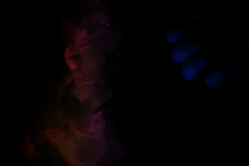 colorful smoke on dark background. Color steam on a black background. Red and blue smoke. Copy space.
