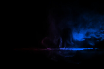 colorful smoke on dark background. Color steam on a black background. Red and blue smoke. Copy space.