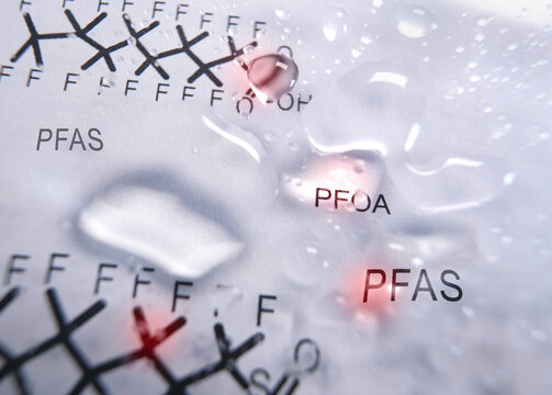 Water droplets with a PFAS text and  chemical structure in the background -- contaminated drinking water concept