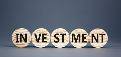 Investment symbol. Concept word Investment on beautiful wooden circles. Beautiful grey background. Business investment concept. Copy space.
