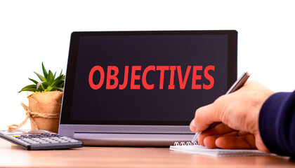 Objectives symbol. Concept word Objectives on beautiful black tablet. Beautiful wooden table white background. Businessman hand with pen. Business objectives concept. Copy space.