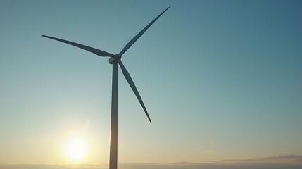 Obraz premium A single wind turbine standing tall against a dramatic sunset. Copy space. 