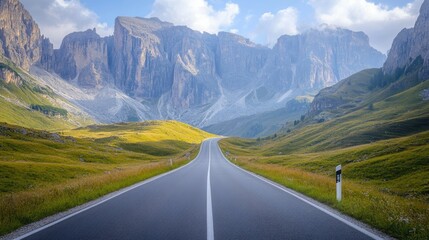 Fototapeta premium A scenic view of an empty road cutting through Venegia Valley, with towering dolomite mountains in the distance.