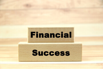 Financial success wording or text on wood block with brown wood background.Copy space and business concept.