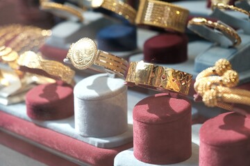 Glass display case with gold women's jewelry. Jewelry on the bust. A gift for a woman. Gold necklace. 