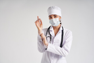 Young doctor putting on surgical gloves over white background